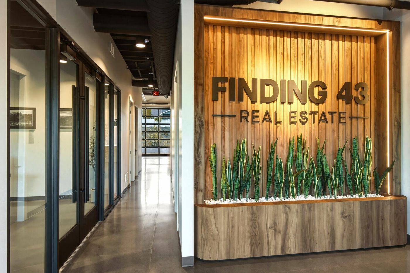 The Finding 43 Real Estate lobby in Meridian, Idaho, with the timber sign wall and a corridor of offices
